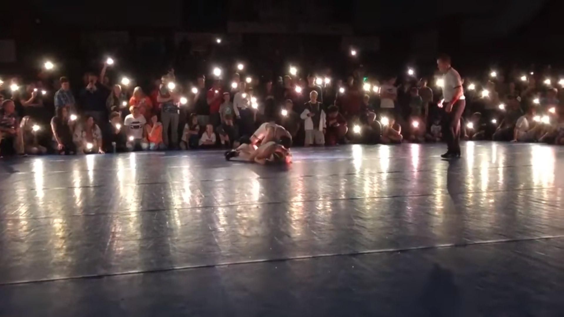 В США зрители турнира по борьбе полностью осветили решающий поединок телефонными фонариками: видео